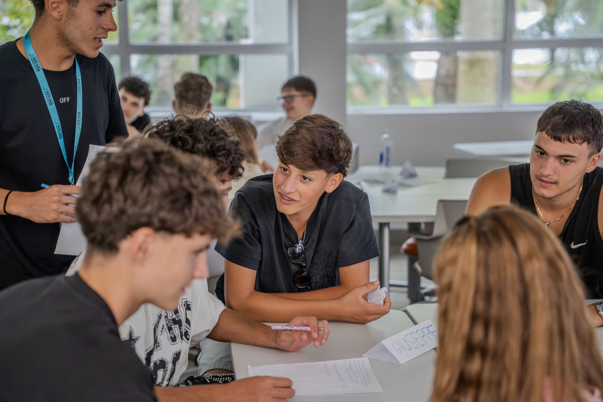 Alunos conversando em inglês durante atividade em grupo
