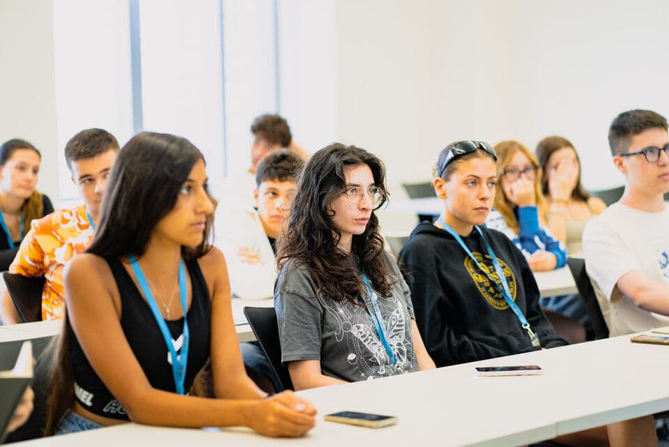 Turma de adolescentes de vários países prestando atenção na aula