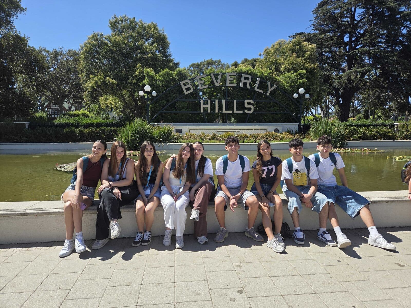 Alunos sentados em frente ao letreiro de Beverly Hills