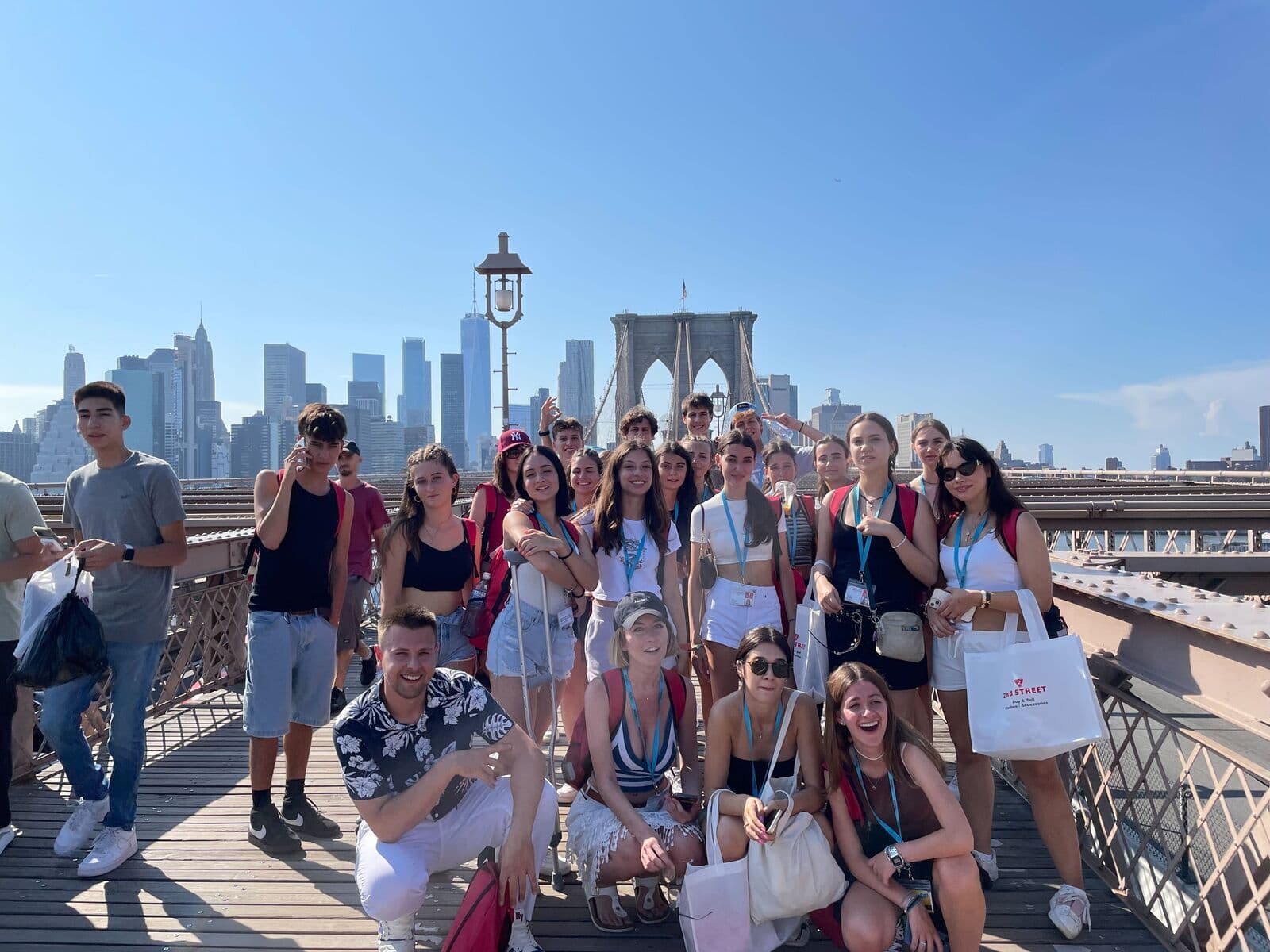 Grupo de alunos na Ponte do Brooklyn, com Manhattan ao fundo