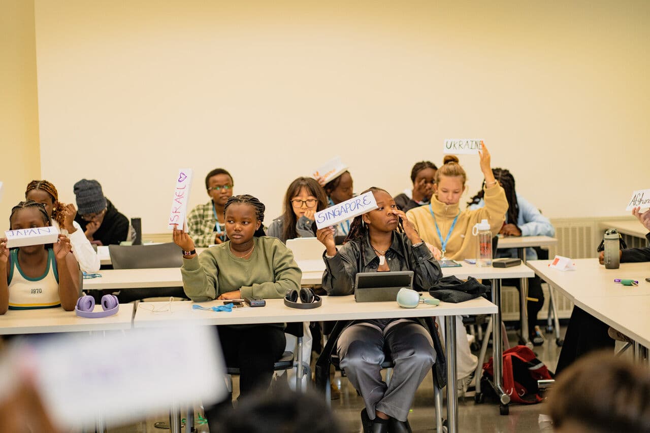 Alunos levantando plaquinhas com nomes de países numa simulação da ONU