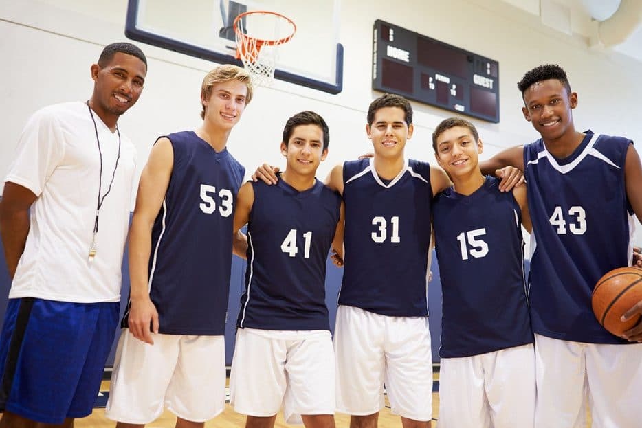 Time de basquete da escola com o técnico