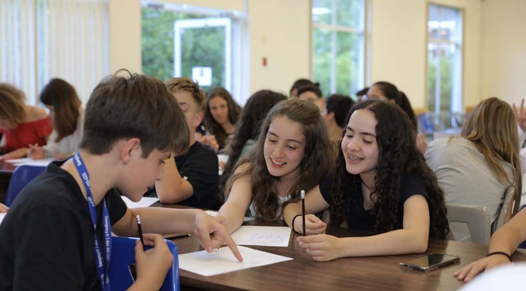Adolescentes de vários países fazendo atividade em grupo na sala de aula