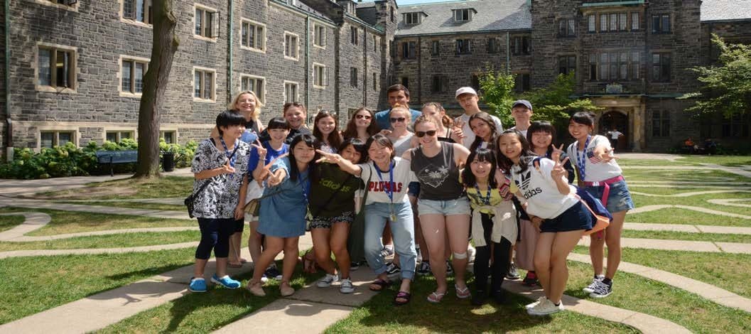 Grupo de adolescentes de vários países no pátio de um campus universitário