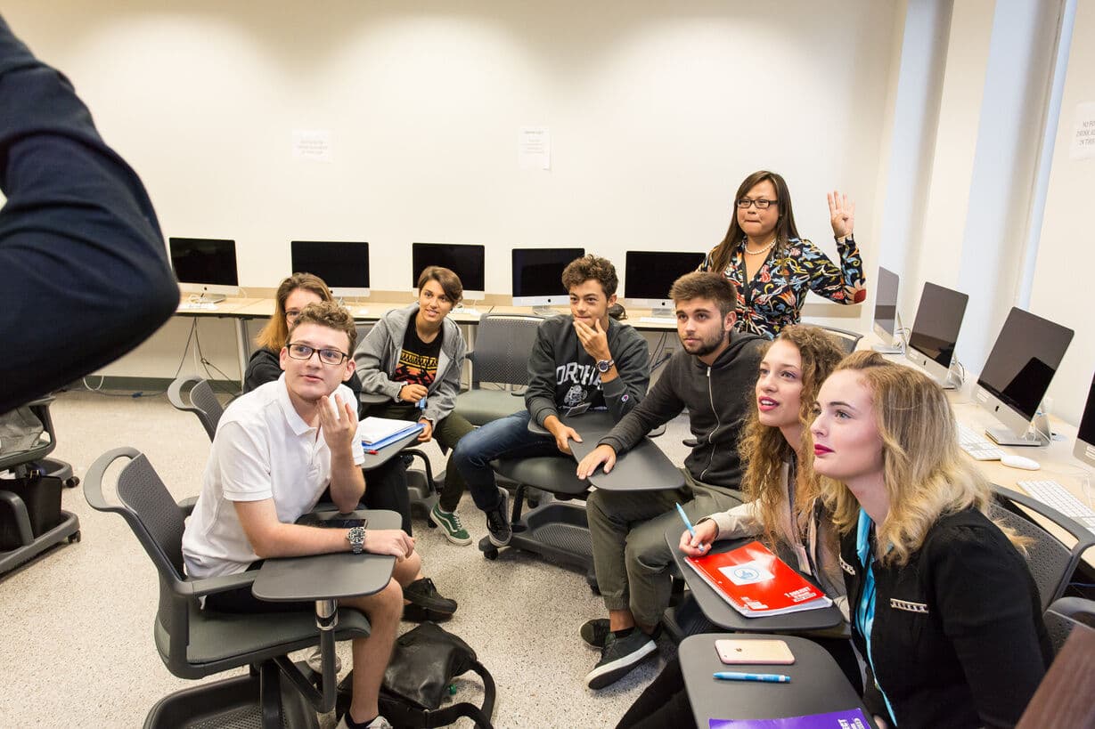 Alunos de vários países em roda durante a aula de inglês